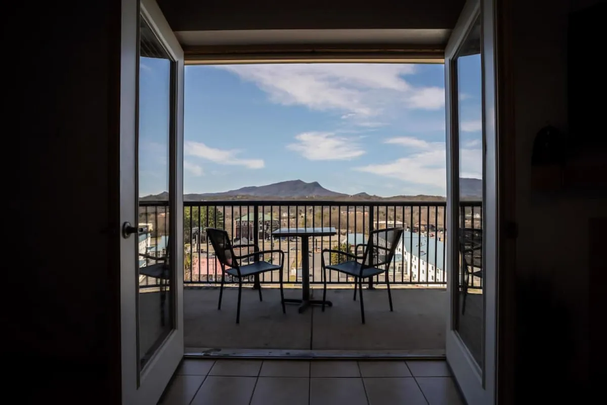 A private balcony with a table and chairs overlooking stunning mountain views. The tranquil setting invites guests to enjoy their morning coffee or an evening toast while basking in the fresh mountain air.